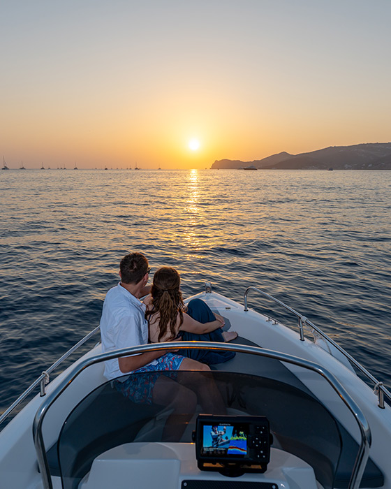 Couple enjoying a romantic sunset on a private boat in Santorini